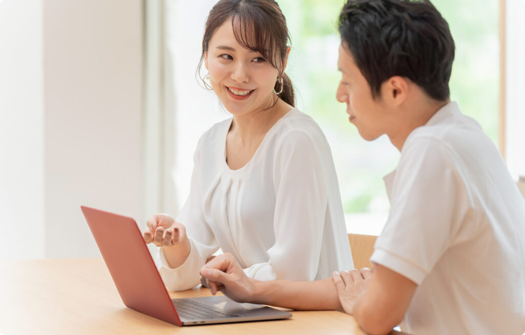 ノートパソコンを使って打ち合わせをする会社員