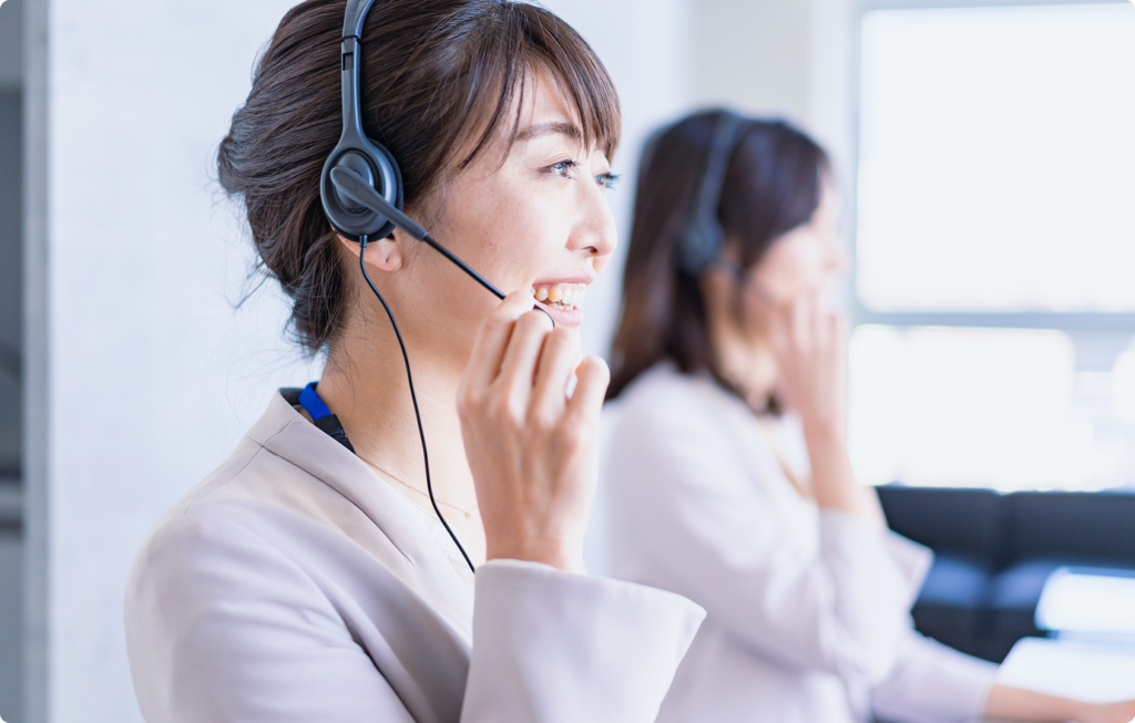 ヘッドセットを着けて電話対応を行うスタッフ